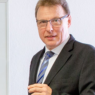 Ein Porträtfoto des Rechtsanwalts Klaus Pahde, ein bebrillter Herr im Anzug schaut freundlich in die Kamera.